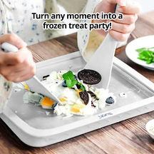 Person using slursh ice cream maker tray to create ice cream treats on a wooden table.