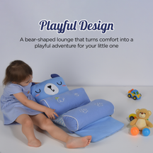 Child playing with a blue bear-shaped trulittle baby head support pilliow on a light gray background