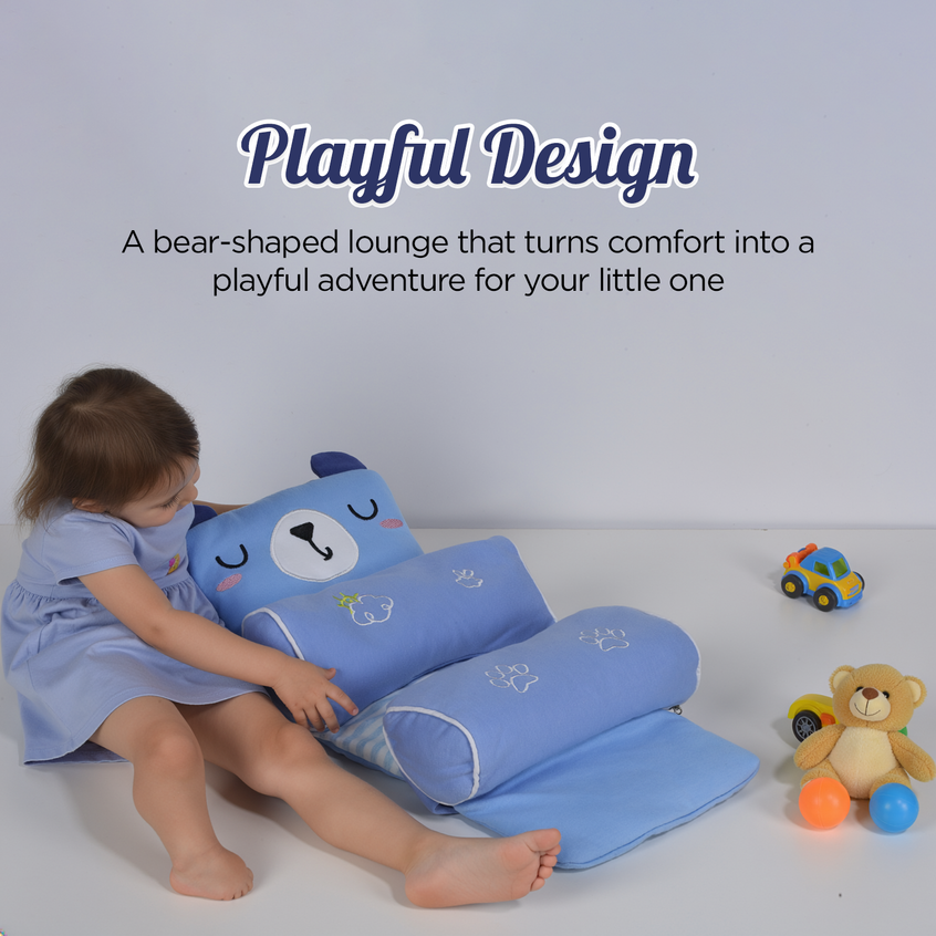 Child playing with a blue bear-shaped trulittle baby head support pilliow on a light gray background