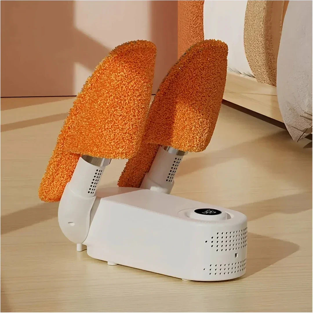 White portable shoe dryer with orange textured covers on a wooden floor.