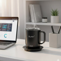 Slursh temperature control smart mug with digital display on a desk next to a laptop